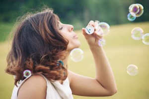 Romantic portrait of young woman with soap balloons.