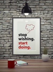Inspirational quote on picture frame over a dirty brick wall. STOP WISHING. START DOING.